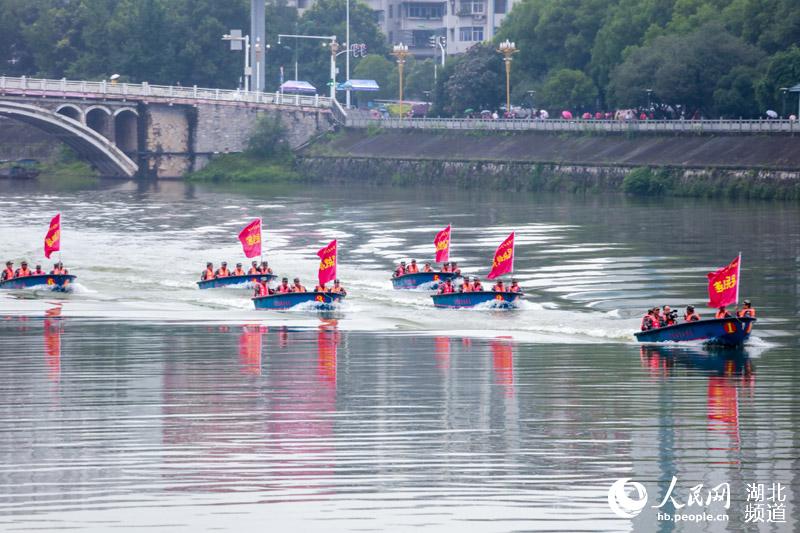 民兵應急分隊駕駛沖鋒舟呈三角形編隊在水面搜索“落”水群眾（朱勇 攝）