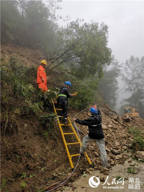 7月17日，國網建始縣供電公司應急搶修隊員在10千伏高廣線河落子村搶修400伏線路。（王永照 攝）