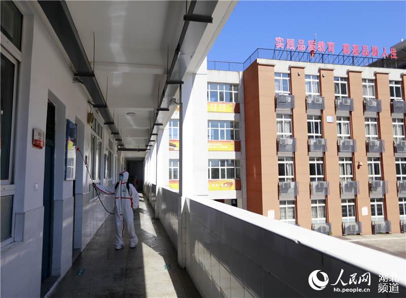 2020年8月3日，在湖北省武漢市第三寄宿中學，2名消防員正在對教學樓走廊進行全面消殺。