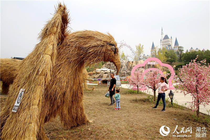 9月26日，游人在湖北省十堰市子胥湖生態新區一園區內觀賞“稻草雕塑”。