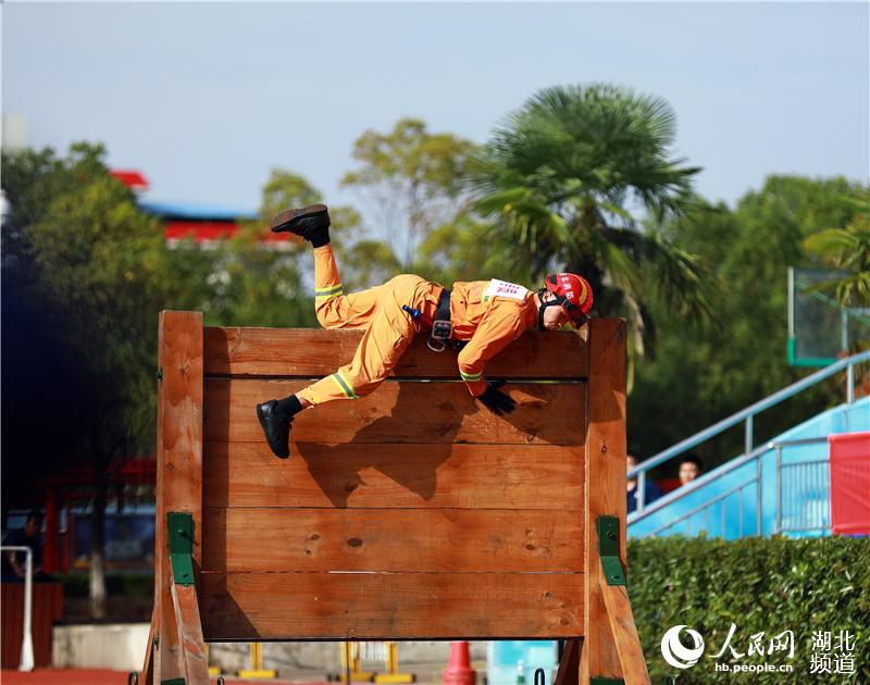 在武漢湯遜湖畔的湖北省消防救援總隊訓練與戰勤保障支隊，參賽隊員正在進行百米障礙救助項目的比拼。（王積歡 攝）