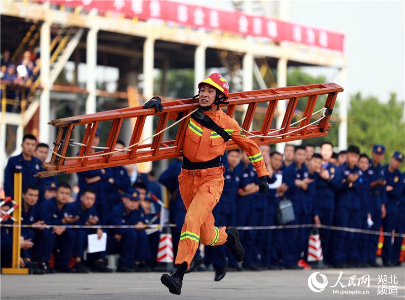 10月22日，在武漢湯遜湖畔的湖北省消防救援總隊訓練與戰勤保障支隊，參賽隊員正在進行60米肩梯登樓項目的比拼（王積歡攝）