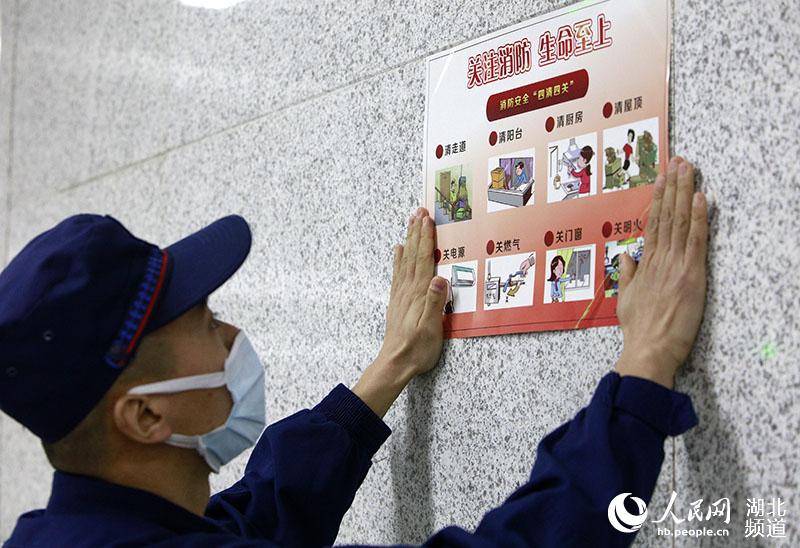1月28日凌晨，在武漢湖北大學地鐵站內，消防員正在張貼消防安全提示海報