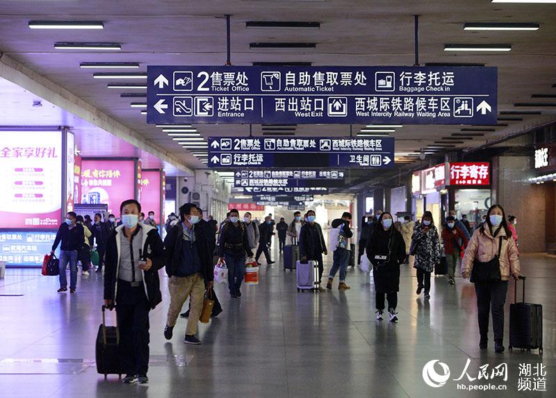 1月28日上午，在武漢武昌火車站出口處，乘客正在有序出站