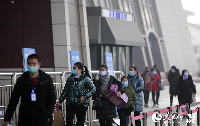 1月28日上午，在武漢武昌火車站外，乘客正在有序進站