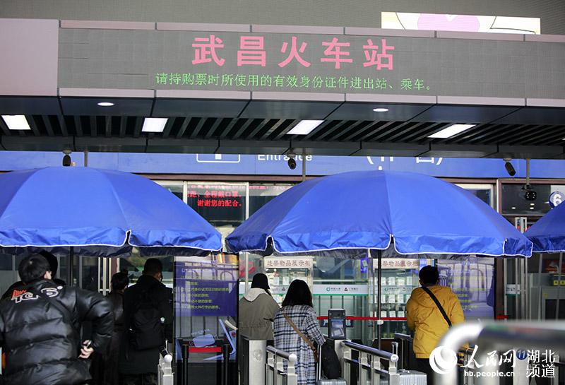 1月28日上午，在武漢武昌火車站外，乘客正在有序進站