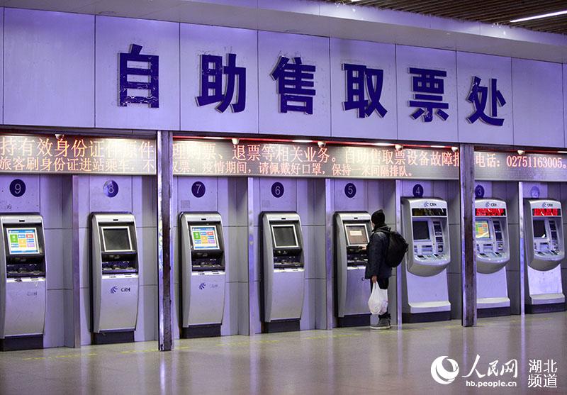 1月28日上午，在武漢武昌火車站自助售取票處，一名乘客正在取票