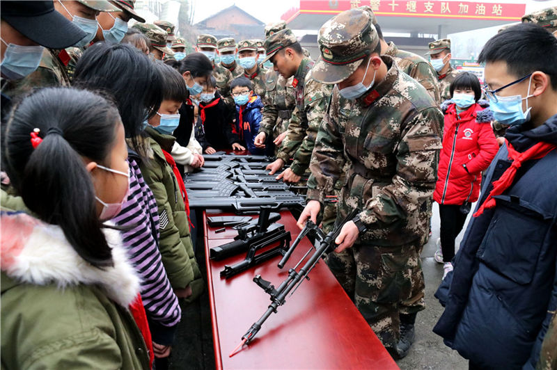 一名武警官兵為孩子們進行武器分解結合演示。