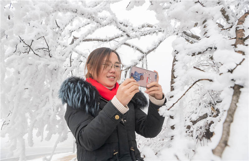 2021年2月28日，游人在湖北省襄陽市保康縣橫沖景區拍攝、欣賞霧凇景觀。