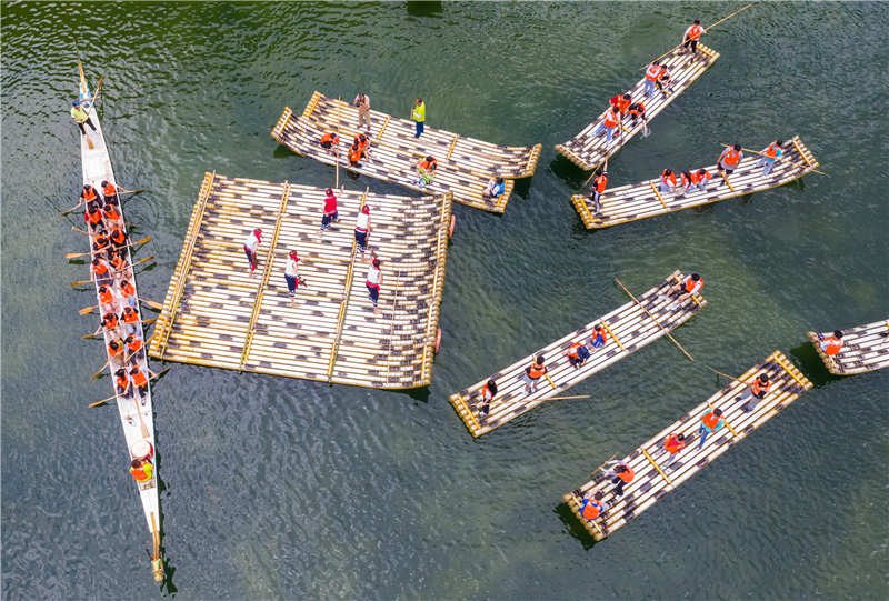 7月4日，在湖北省宜昌市秭歸縣三峽竹海生態景區內，非遺傳承人在為游客表演國家級非遺項目“長江峽江號子”（無人機照片）。