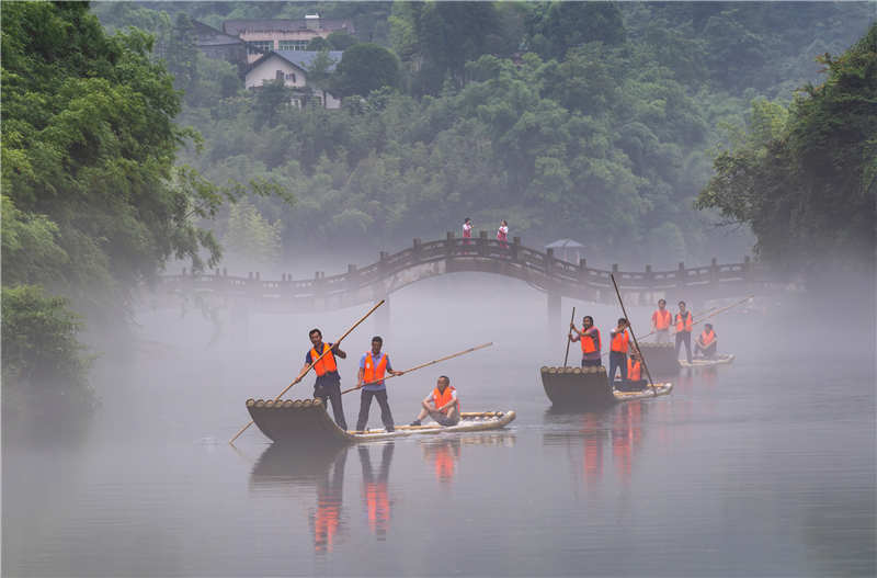 7月5日，在湖北省宜昌市秭歸縣三峽竹海生態風景區內，非遺傳承人在橋上為游客演唱省級非遺項目“秭歸薅草鑼鼓”。