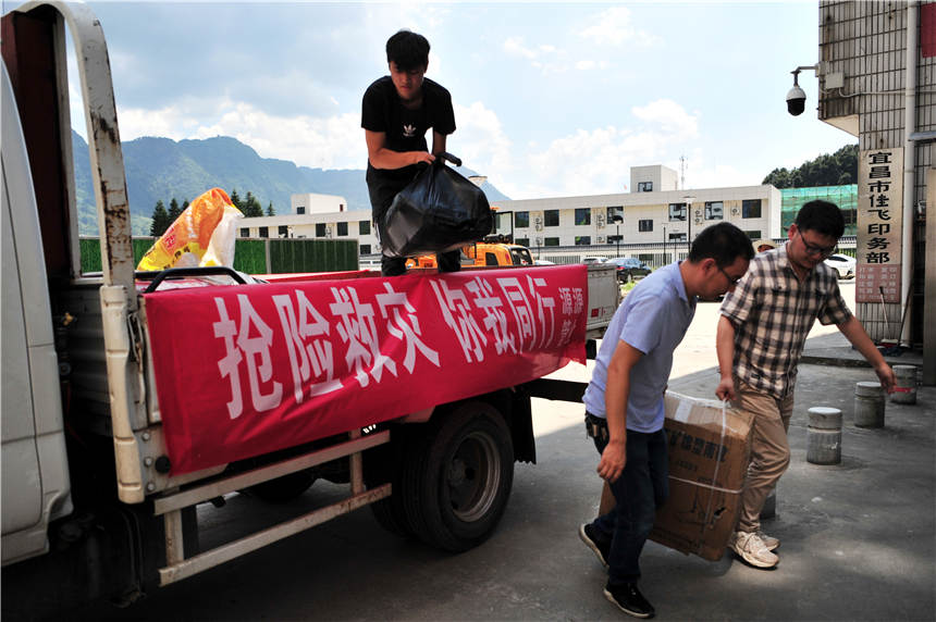 7月25日，志願者在搬運湖北省宜昌市夷陵區樂天溪鎮遭受洪澇災害后愛心企業和各界人士捐贈的救災物質。