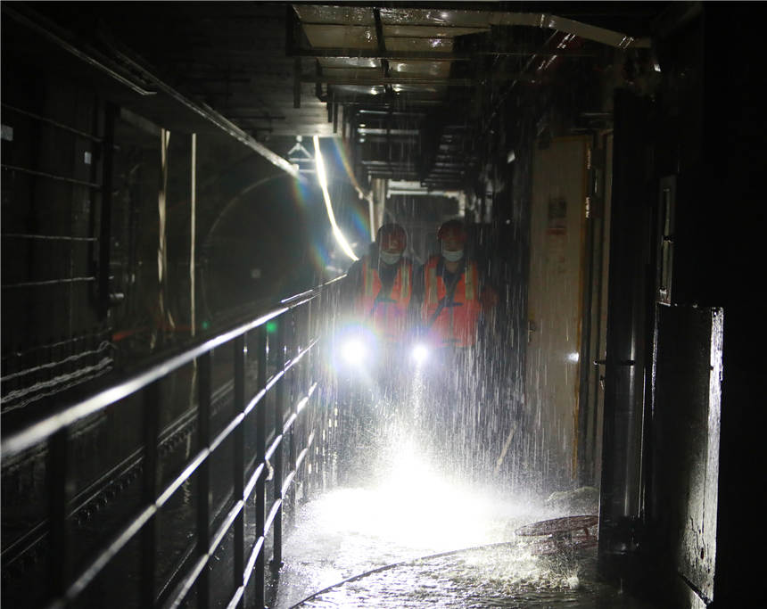 7月30日，在鄭州地鐵3號線東十裡鋪站，湖北武漢消防指戰員正在查看地鐵軌道沿線排澇情況。