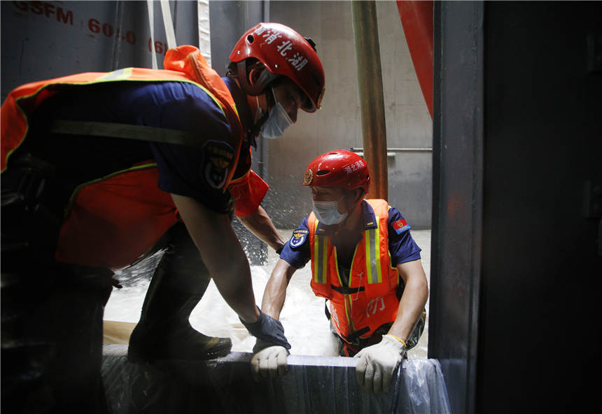 7月30日，在鄭州地鐵3號線東十裡鋪站，湖北武漢消防指戰員完成水泵周邊雜物清理。