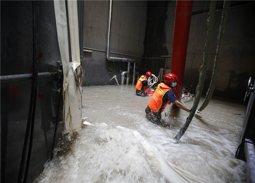 7月30日，在鄭州地鐵3號線東十裡鋪站，湖北武漢消防指戰員正在調整水泵位置1。