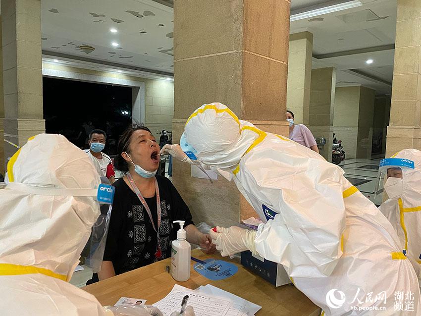 2021年8月3日21时40分，武汉市洪山区泓悦府小区居民正在排队等候做核酸检测。人民网 周恬摄