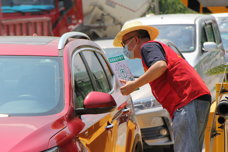 志願者在高速路口參與疫情防控工作，開展體溫測量與健康碼、出行碼核驗 