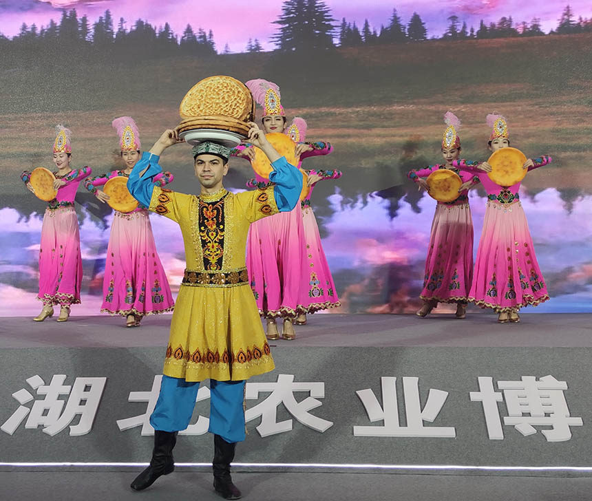11月27日下午，在新疆馕產業推介會暨特色農產品交易會(武漢)啟動儀式上，參展的龍頭企業員工與"馕"載歌載舞，答謝湖北武漢人民。
