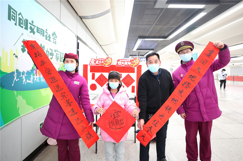 武漢地鐵后湖大道站乘客展示所寫春聯。