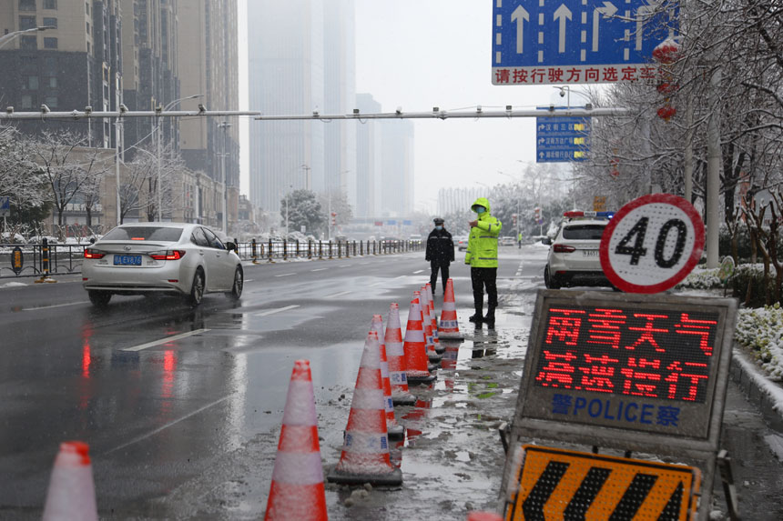 針對雨雪天氣，武昌區交通大隊迅速啟動惡劣天氣應對預案，夜間通宵巡查路面結冰情況。7日早高峰期間，在各橋隧、易結冰路口增加警力布置，設置移動電子警示牌，指揮車輛安全行駛。高梓健攝