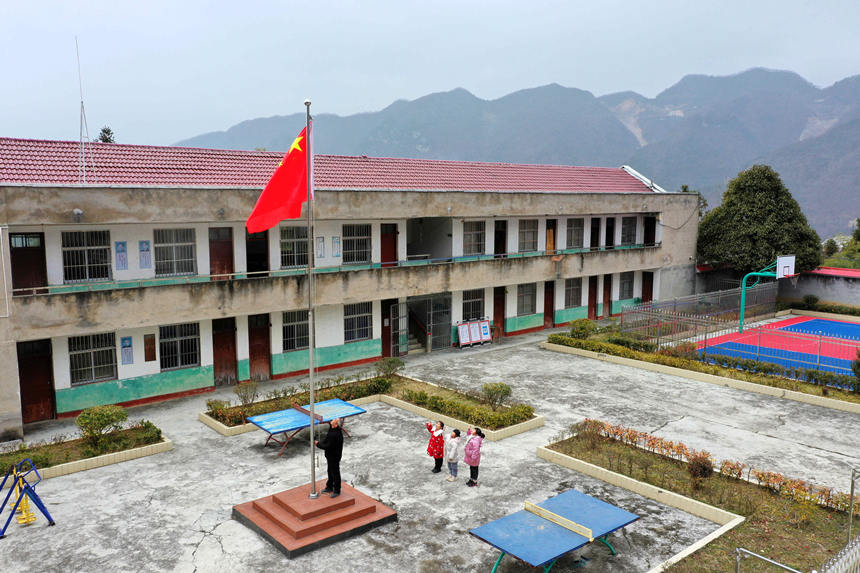 2月16日，在湖北省襄阳市保康县马桥镇峰山村教学点，教师李吉川带领学生举行开学升旗仪式。