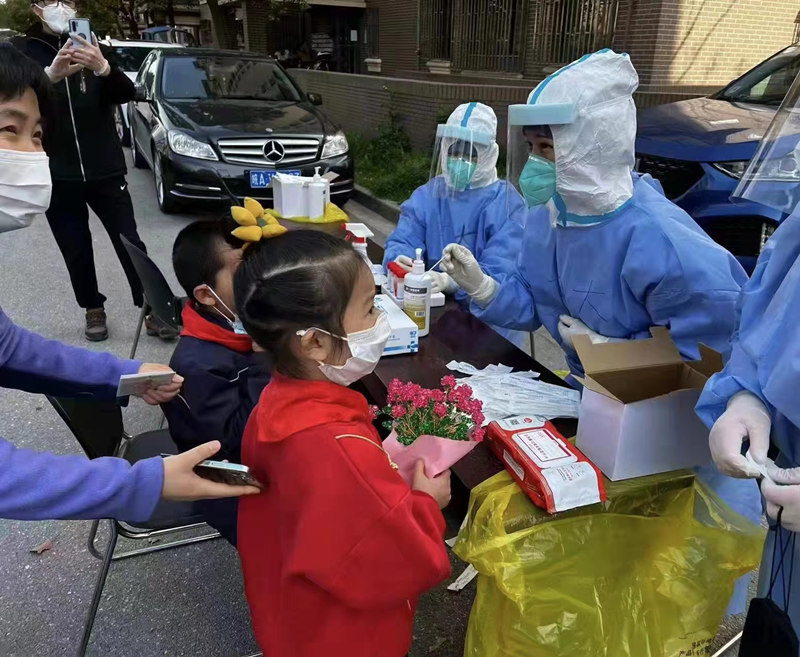 上海小姑娘向武漢大學口腔醫院醫療隊員遞上一束手工水晶花。受訪者供圖