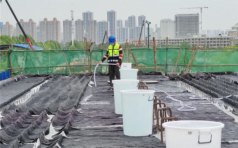 武漢市軌道交通5號線二期工程首片梁順利澆筑完成，工人在澆水養護
