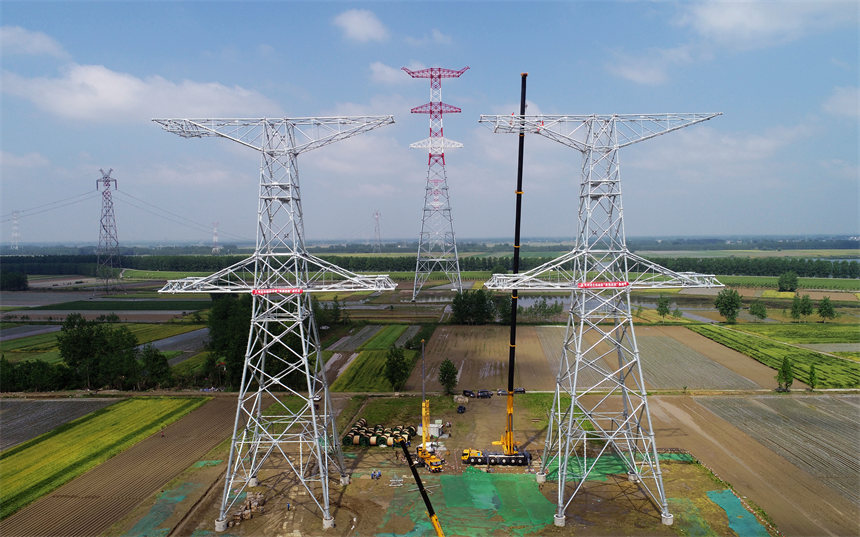 国网湖北电力施工人员吊装1000千伏荆门至武汉输电线路1049L号铁塔。邹小民摄
