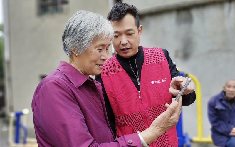 移动工作人员手把手教农村老人使用智能手机