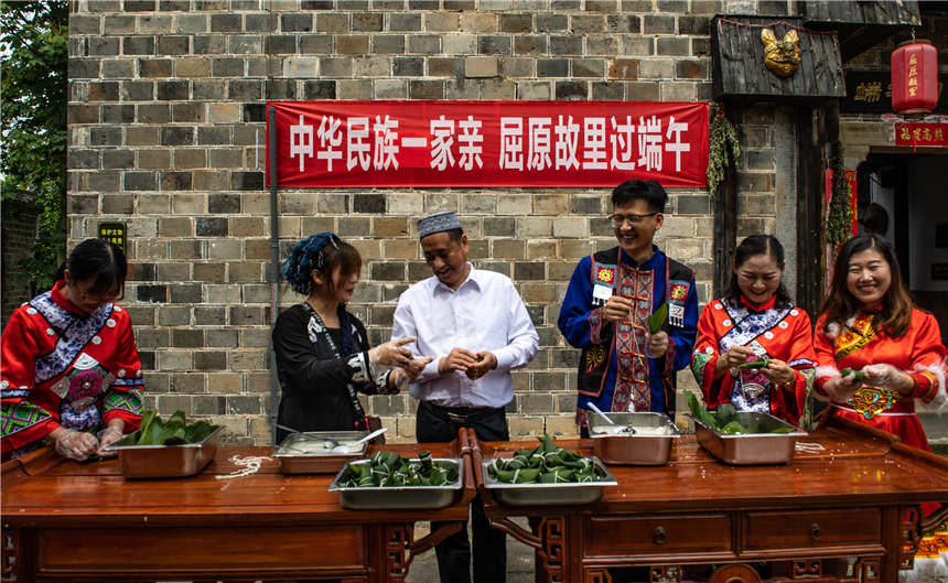 各民族代表在屈原故里景区端午习俗馆一起包粽子。郑家裕摄