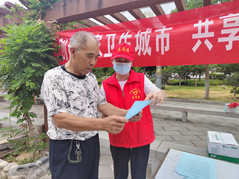 志願者們向公園群眾發放文明倡議書。