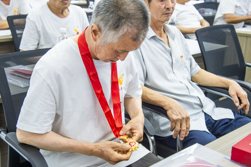 在老党员谭维德的带领下,参加活动的党员集体重温入党誓词。