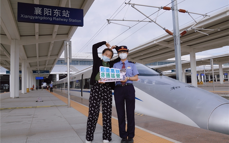 郑渝高铁开通首日，旅客和乘务员合影留恋。李涛摄
