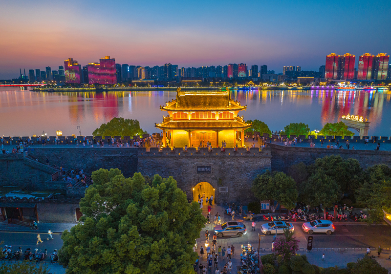 湖北省襄阳古城北街和临汉门亮起霓虹灯，吸引了众多市民和游客游玩，欣赏流光溢彩的古城夜景。