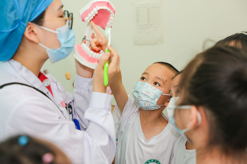 口腔科醫生向小朋友講解正確刷牙方法。武漢市中心醫院供圖