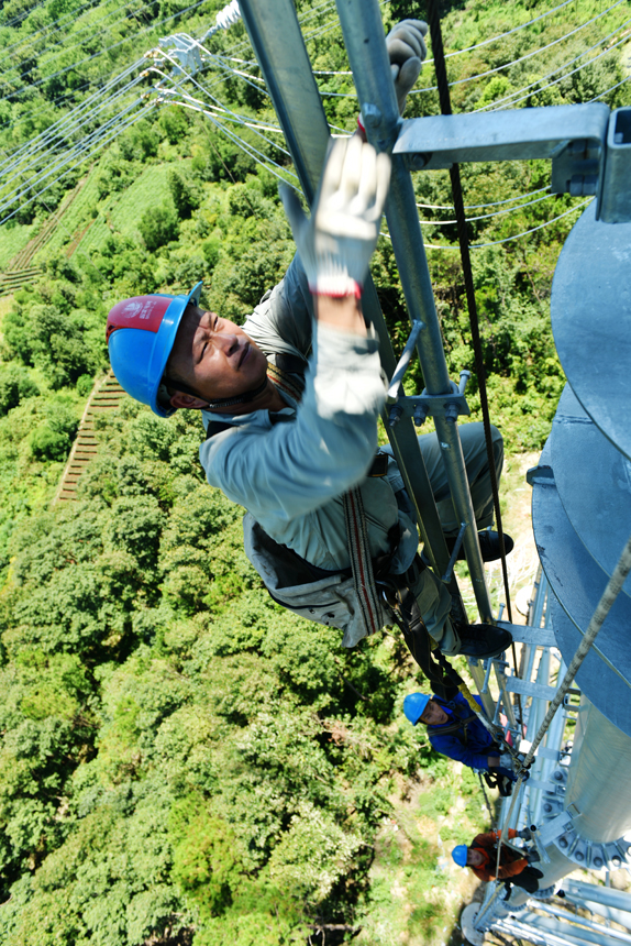 國網湖北送變電工程有限公司施工人員攀登百米高塔。