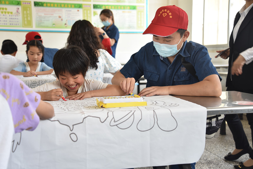 红色志愿队与对口村小学生一起欢度“六一”。