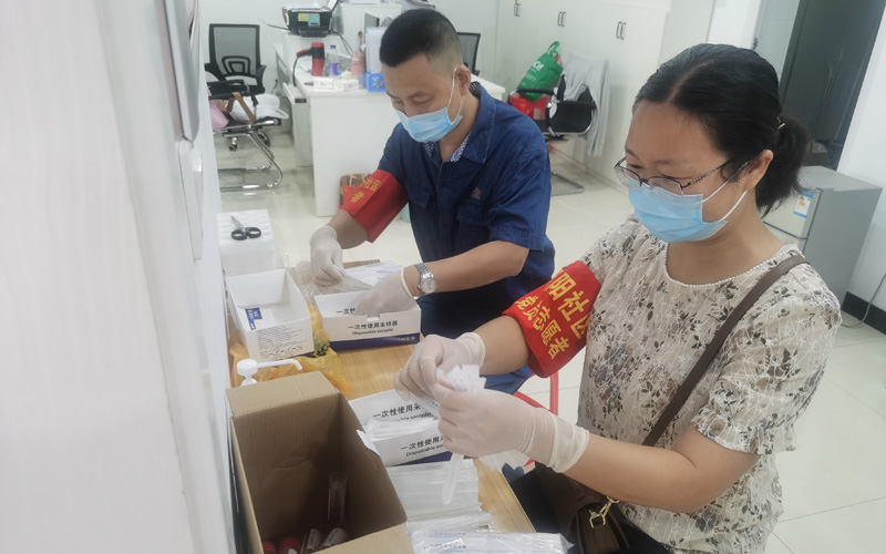 襄阳卷烟厂职工曾辉、王艳协助社区工作人员整理核算检测器材。