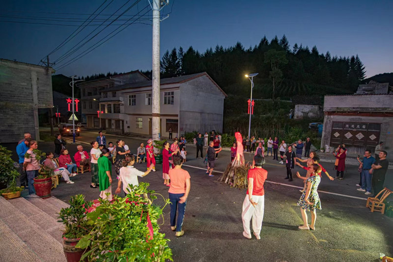 游客与当地村民在篝火旁跳舞 。