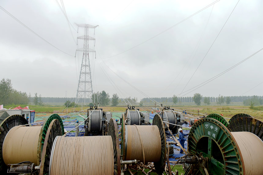國網湖北送變電公司施工人員操作張力機展放跨漢江導線。鄒小民攝