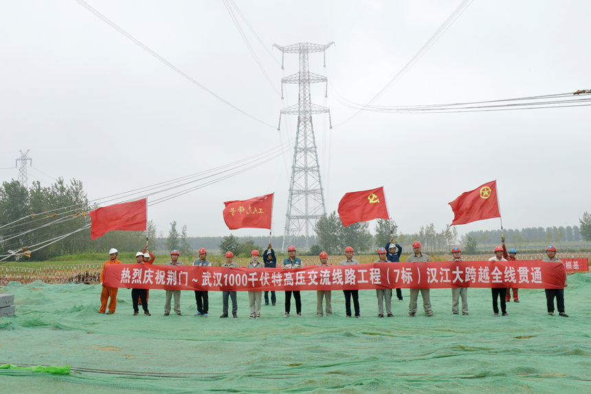 施工现场参建人员庆祝跨汉江线路贯通。邹小民摄