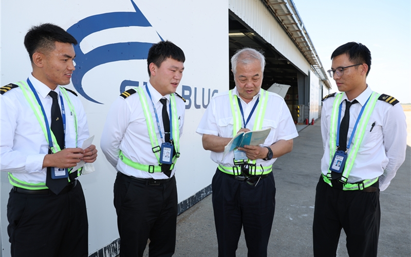 吴光辉（右二）与蔚蓝航空襄阳基地年轻学员交流学习心得。