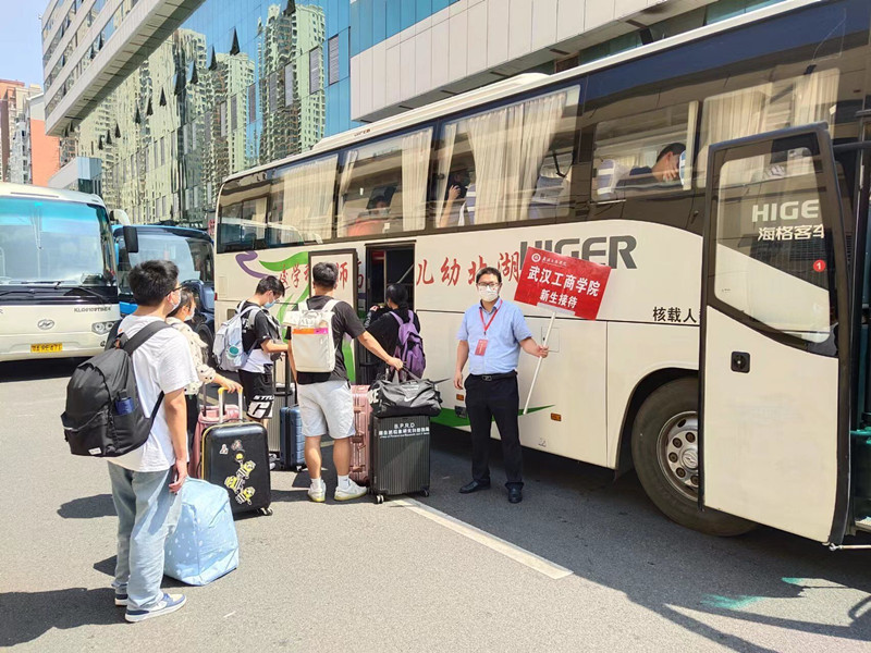 教工志願者在火車站迎接新生。