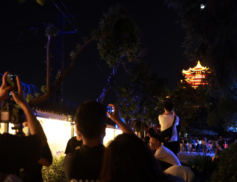 这是9月11日晚在湖北省武汉市黄鹤楼下拍摄的不少市民正在拍照赏月。