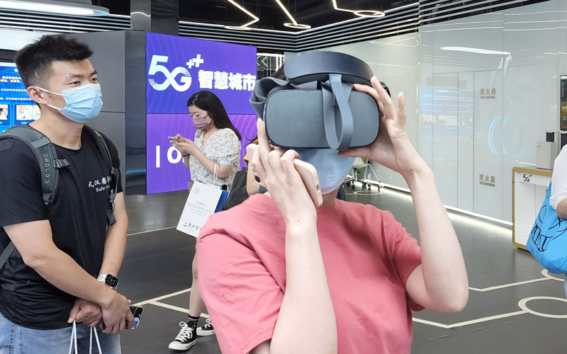 觀眾借助VR眼鏡體驗5G通信技術應用成果。