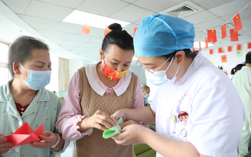 迎重阳，庆国庆的安宁疗护活动中患者和护士们一起折纸鹤。