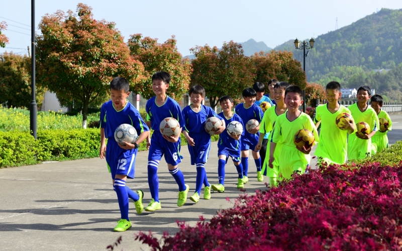 竹山县上庸镇九年一贯制校园足球队入场。