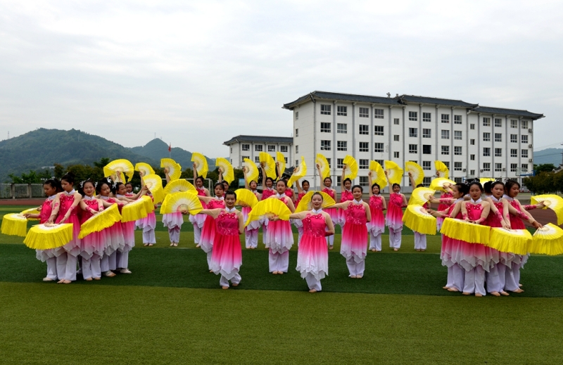 竹山县上庸镇九年一贯制学校学生课后在操场上排练扇子舞。