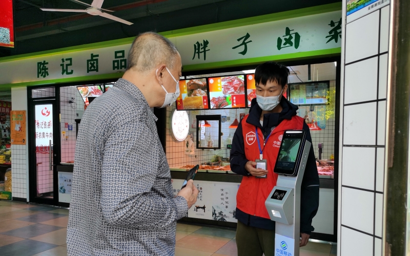 市民通过“防疫哨兵”进入菜场。