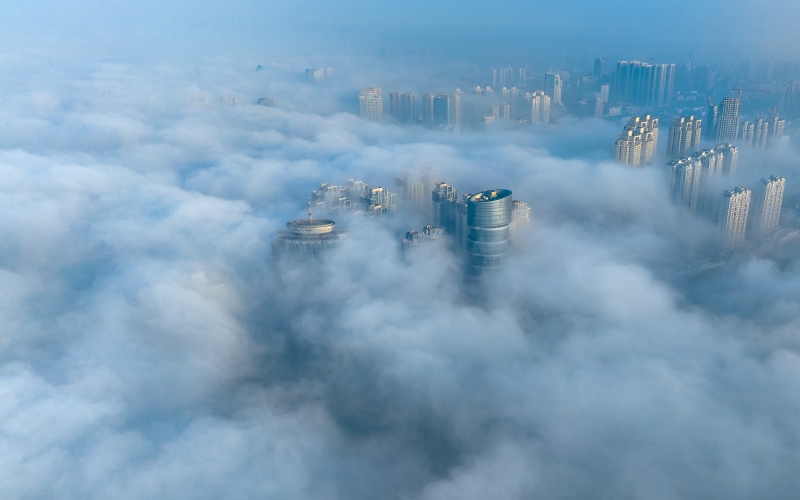 湖北省襄阳市汉江两岸出现平流雾景观，城市景观在雾气中若隐若现。